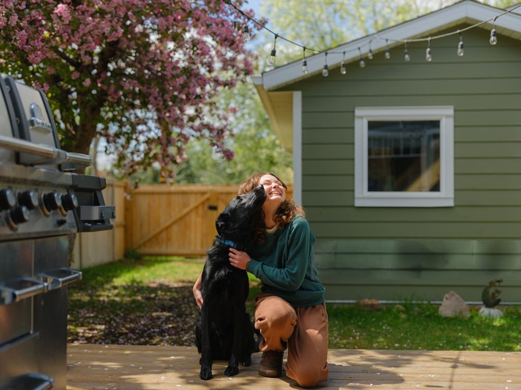 Femme passant du temps avec un chien noir dans un jardin