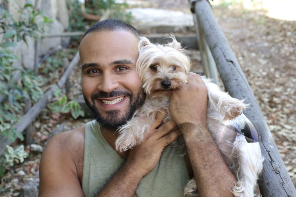 Homme souriant tout en tenant un petit chien