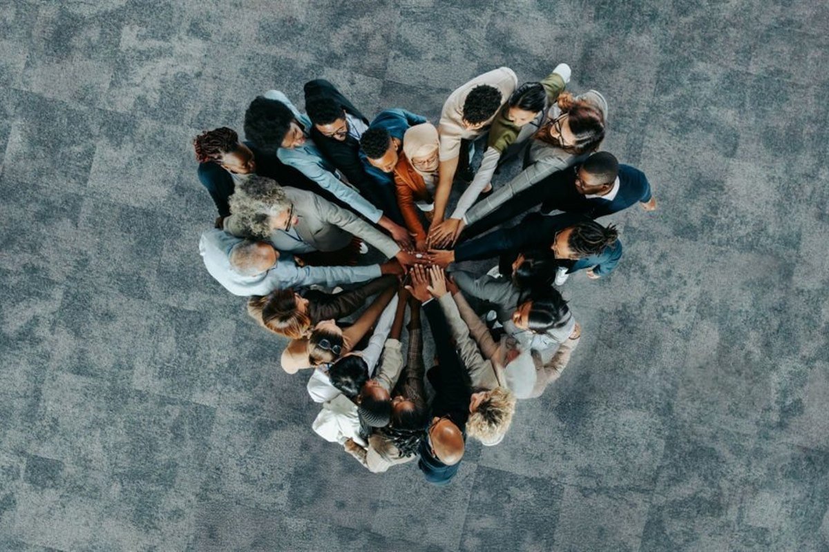 A diverse team joining hands in a circle