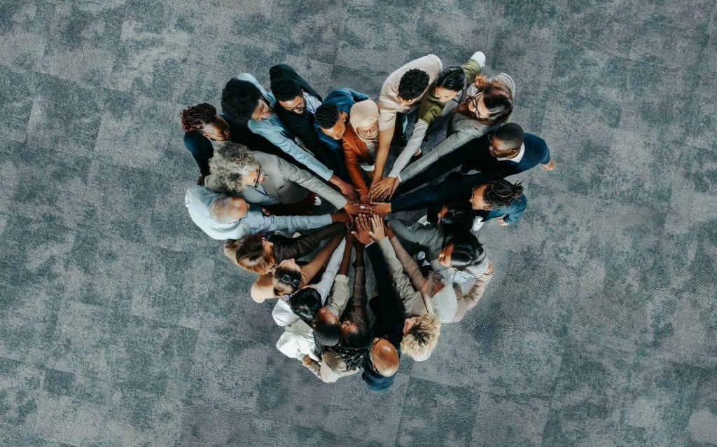 A diverse team joining hands in a circle